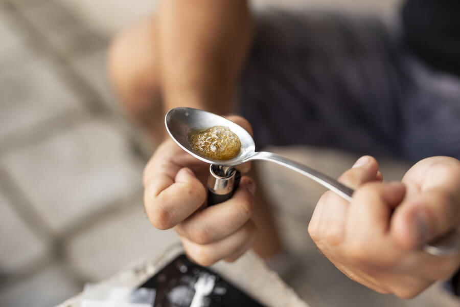 High Angle View Of Male Hands Cooking Heroin In A Spoon 