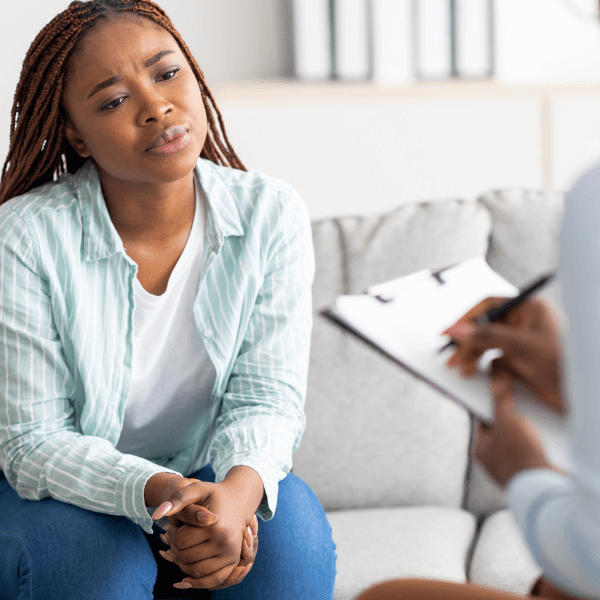 Young black woman with a concerned face talking to her therpaist